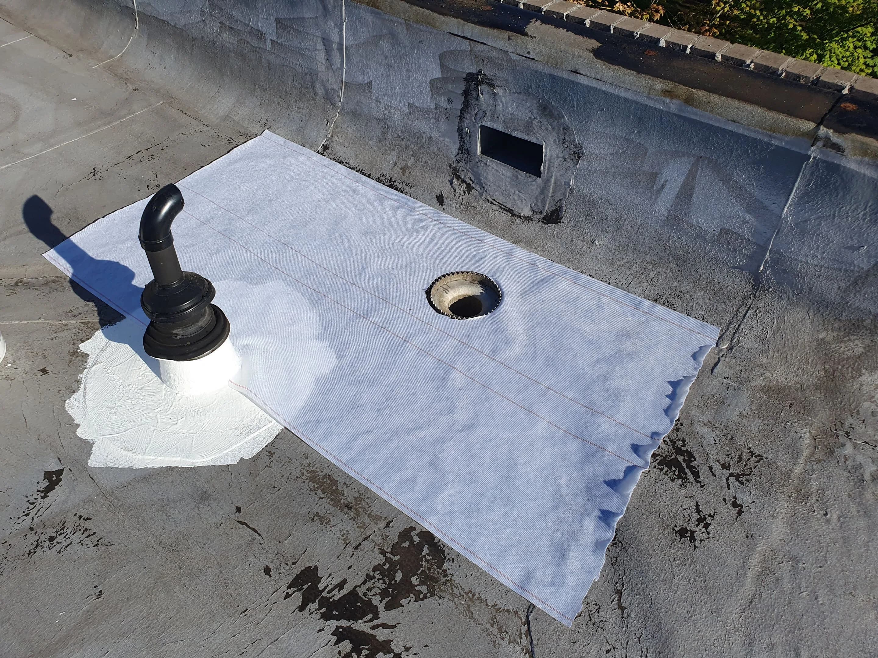 Commercial roof preparation and reinforcement work around a penetration and drainage detail