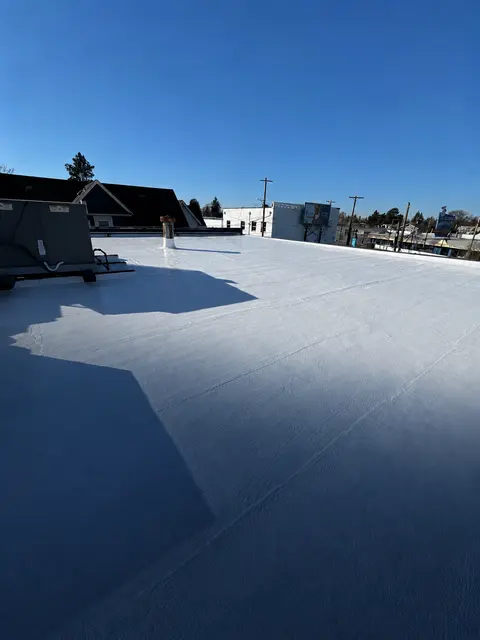 Restored white commercial roof with rooftop mechanical equipment